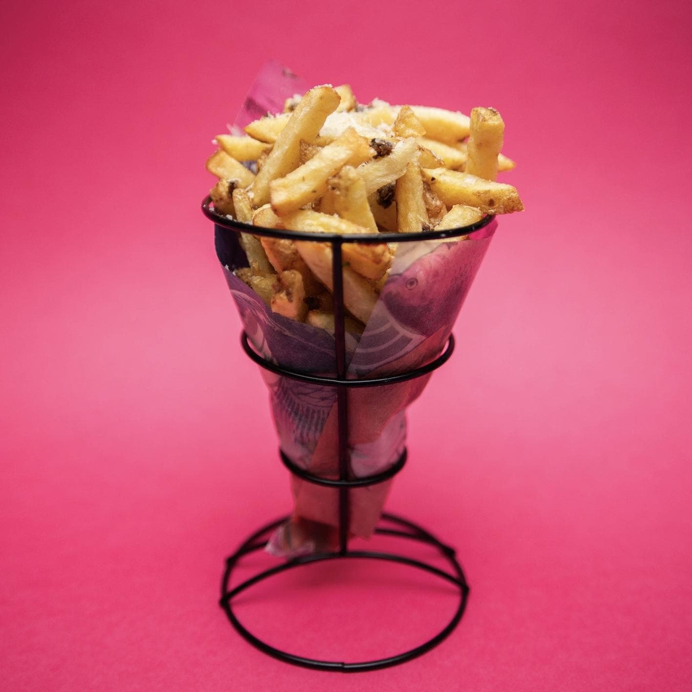 fries in a basket with salt and parmesan on top