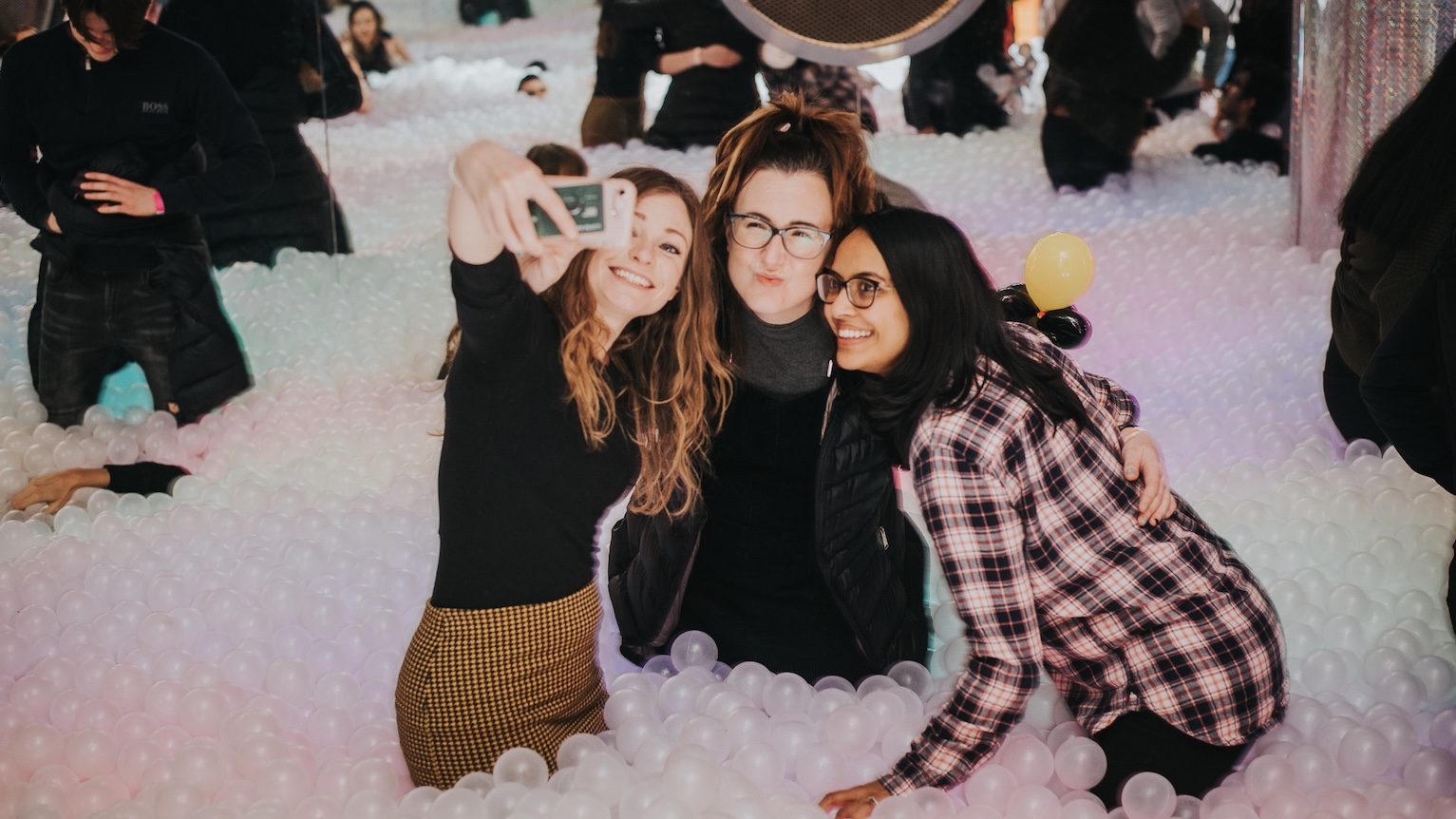 three girls taking a selfie in a giant ball pit