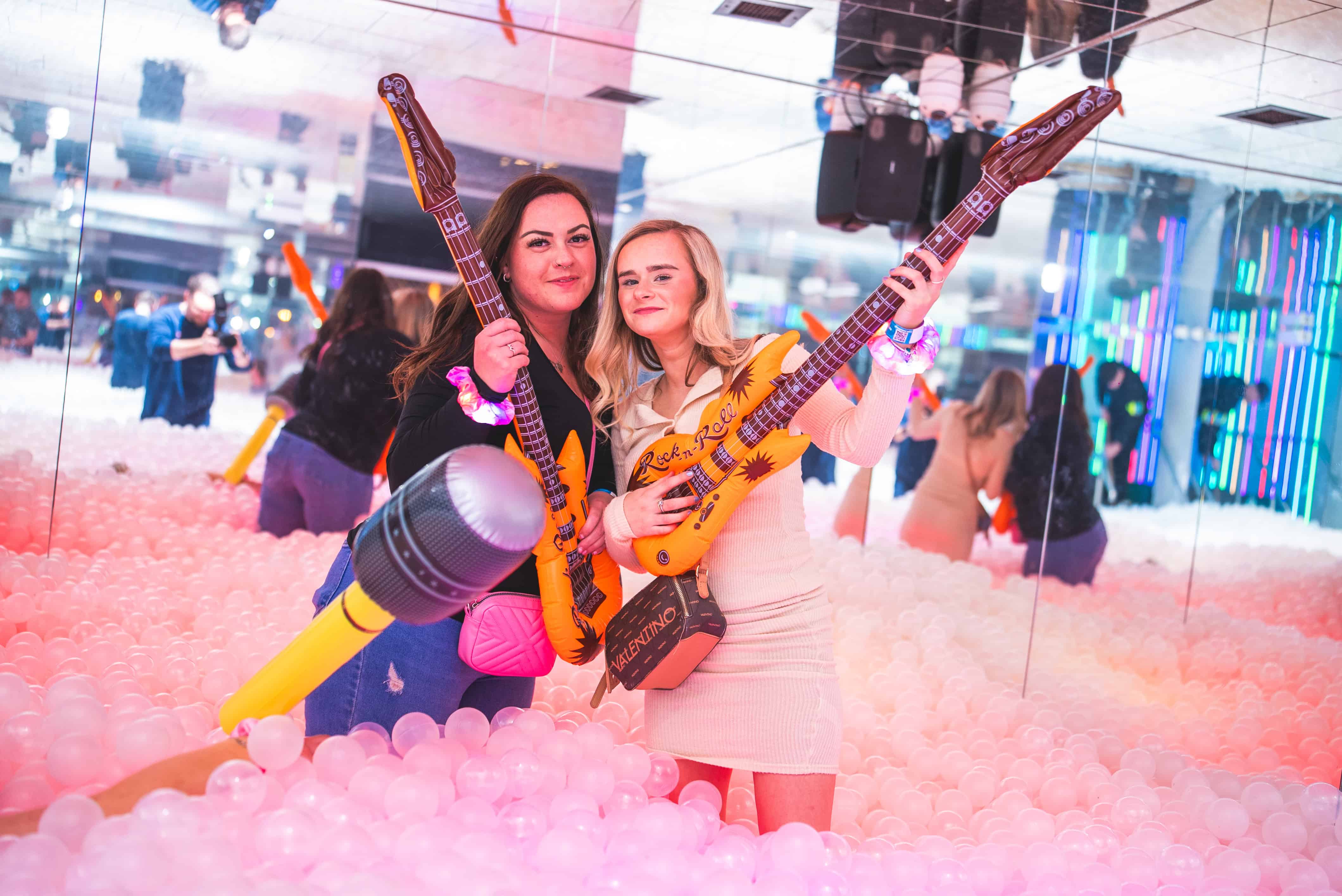 three girls singing along to karaoke with sparklers and microphone in hands