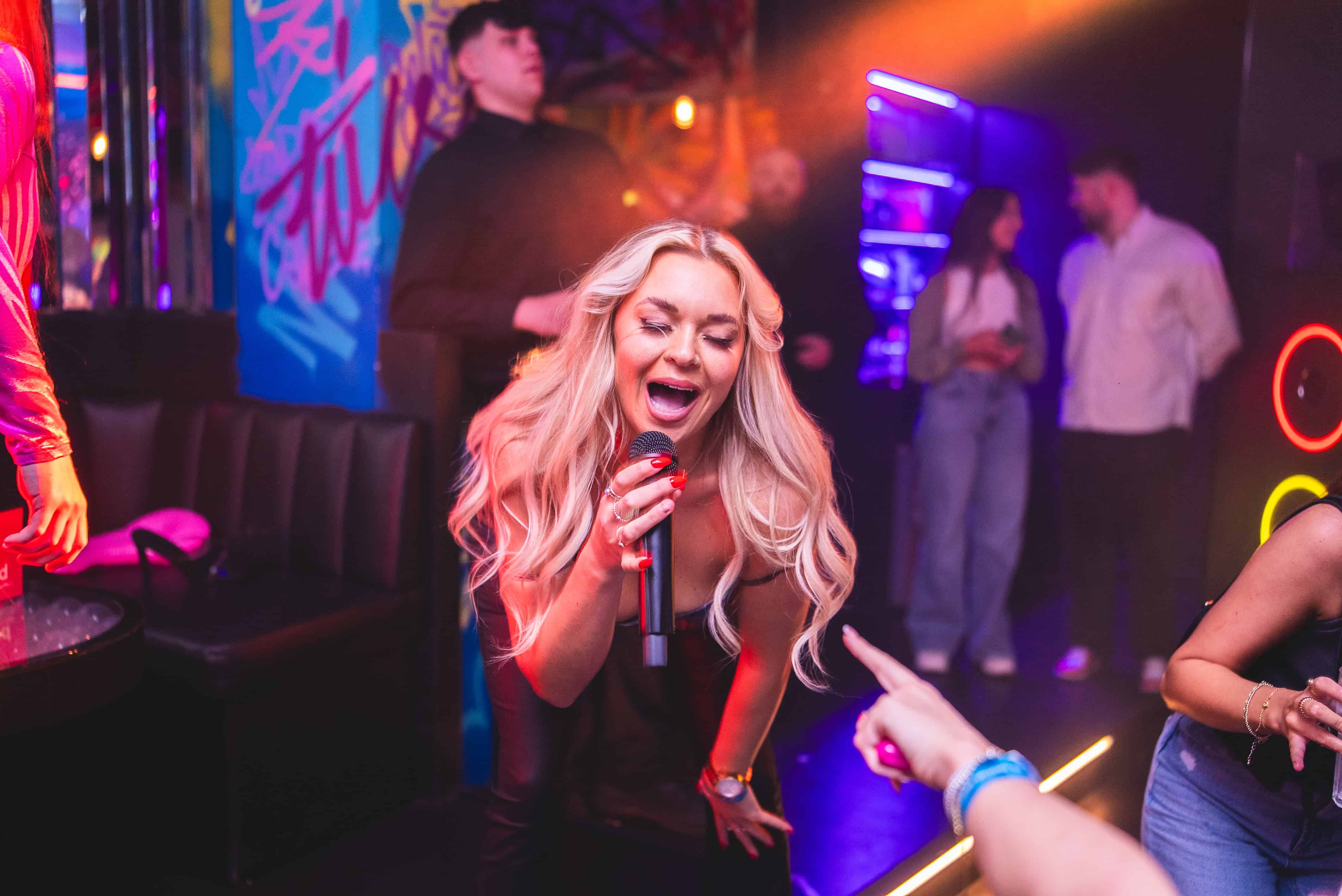a group of friends drinking prosecco, one man is holding a birthday cake with sparklers sticking out of the top