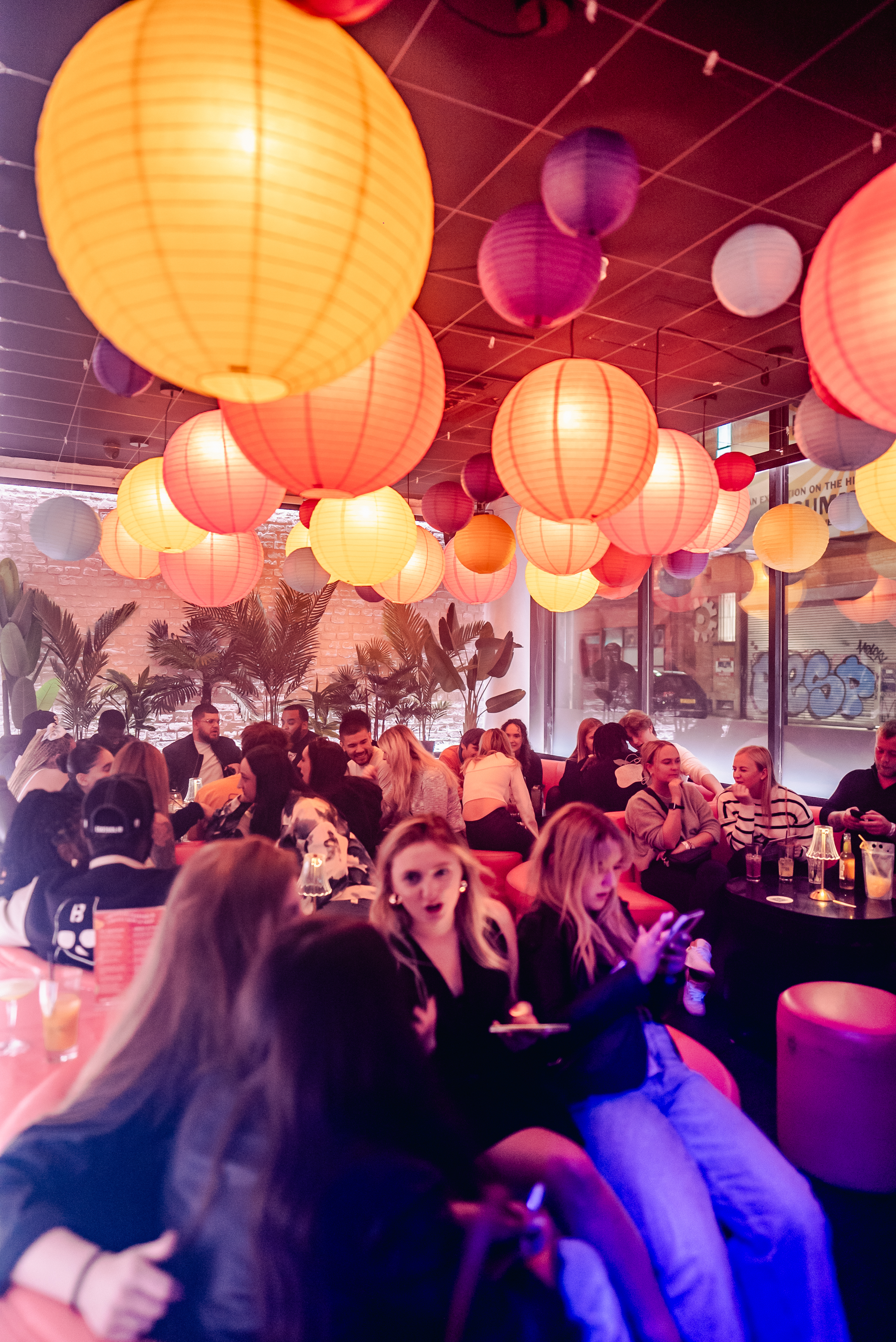 a full dance floor with people partying, listening to the DJ and confetti falling from the ceiling