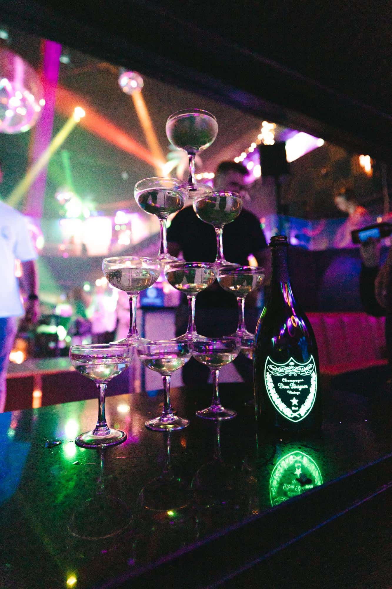 Champagne in glasses with colourful nightclub lights at Ballie Ballerson, London.