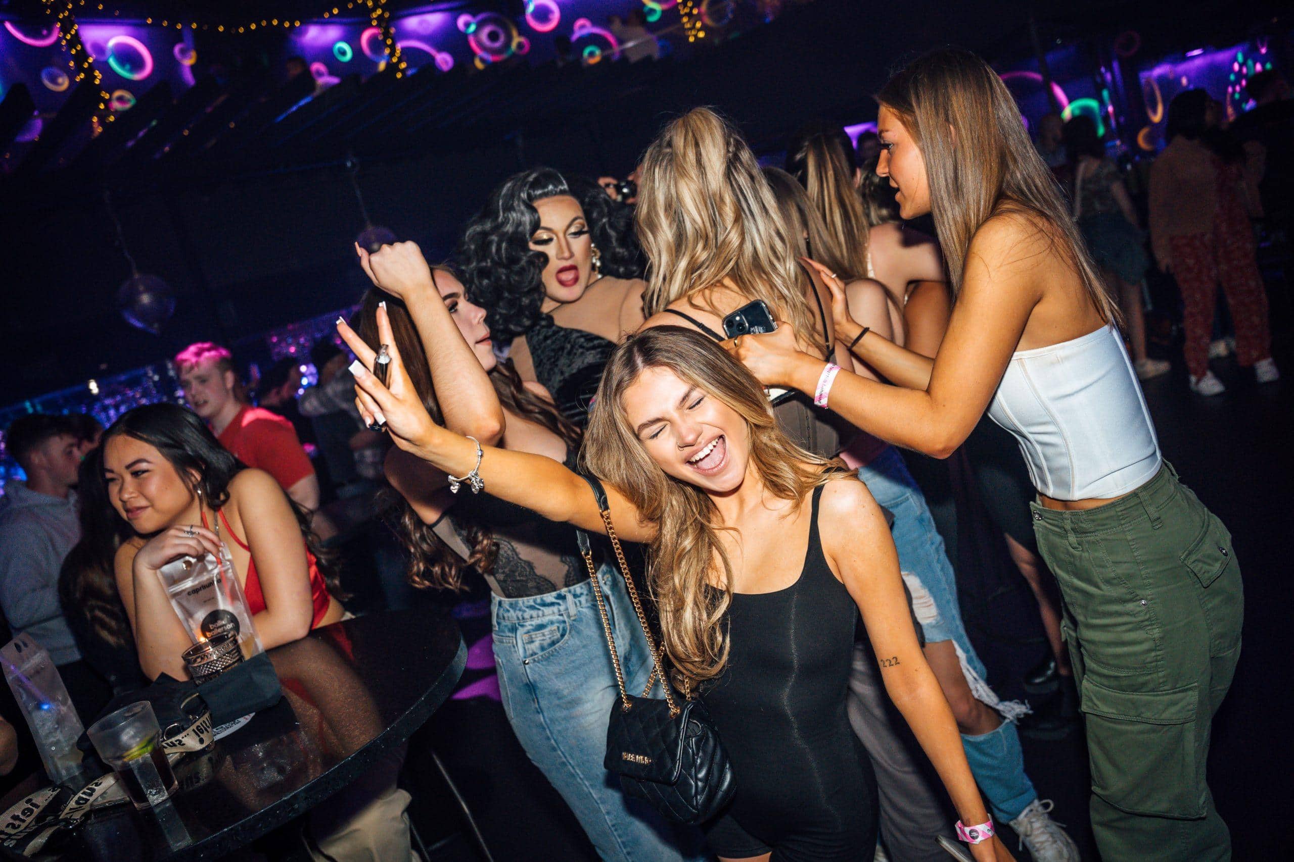 Energised women dancing and celebrating at Ballie Ballerson's colourful ball pit party venue.