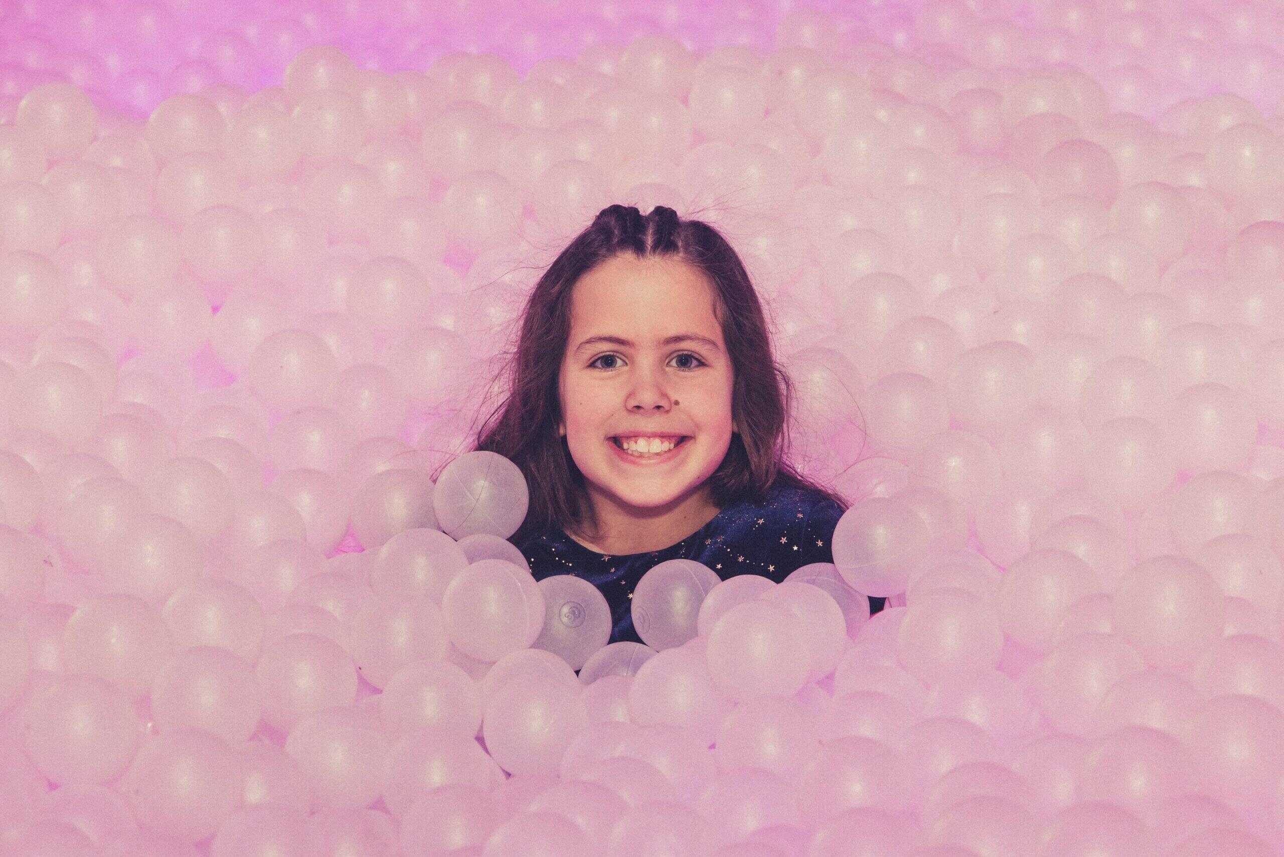 Colourful ball pit at Ballie Ballerson with happy smiling child in London.