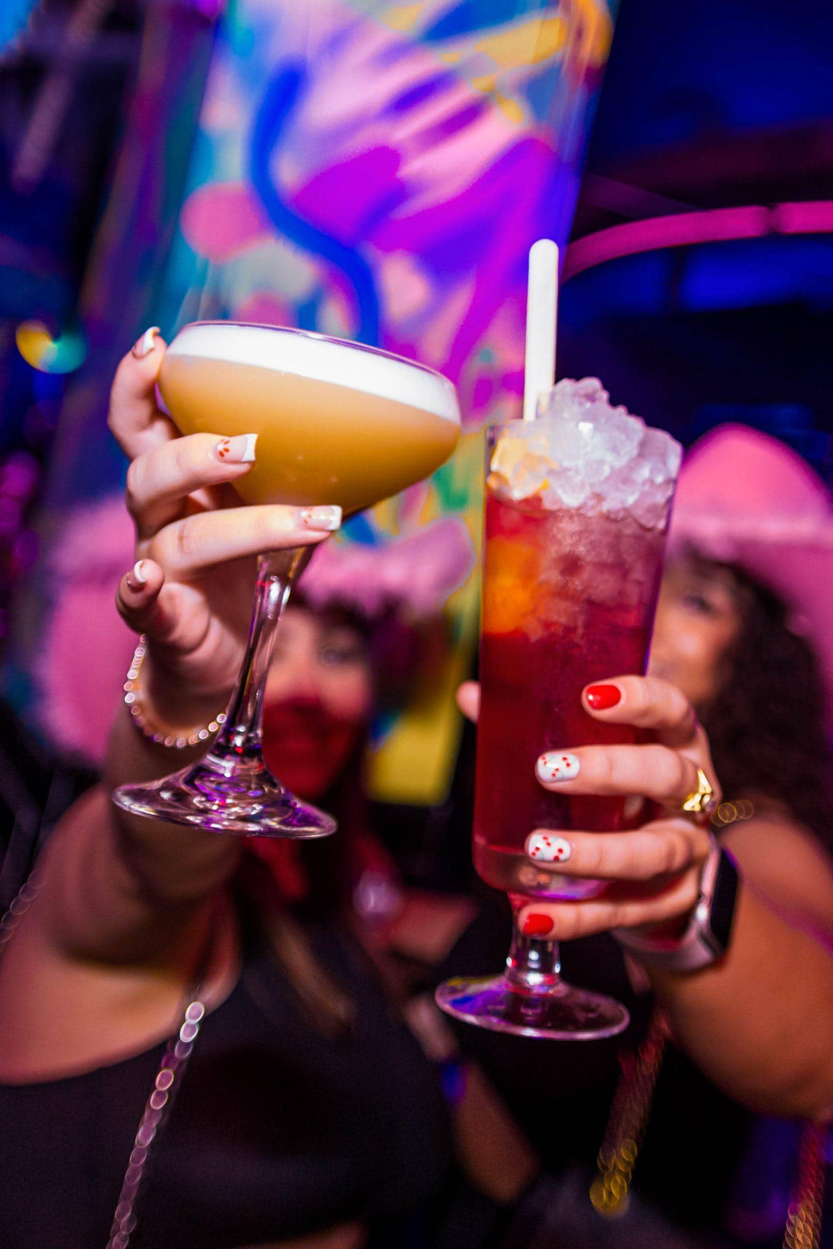 Vibrant passion fruit cocktail with halved passion fruits on a colourful table and background.