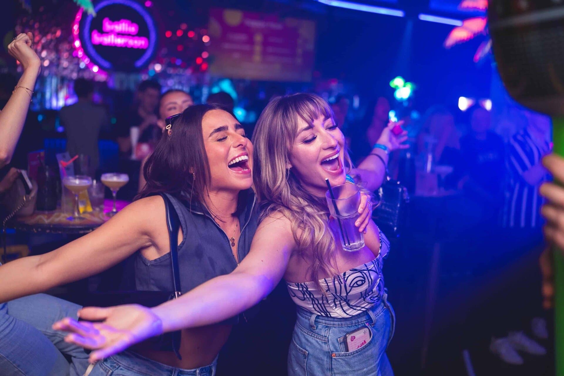 Vibrant ball pit with party guests, colourful lighting, fun atmosphere at Ballie Ballerson.